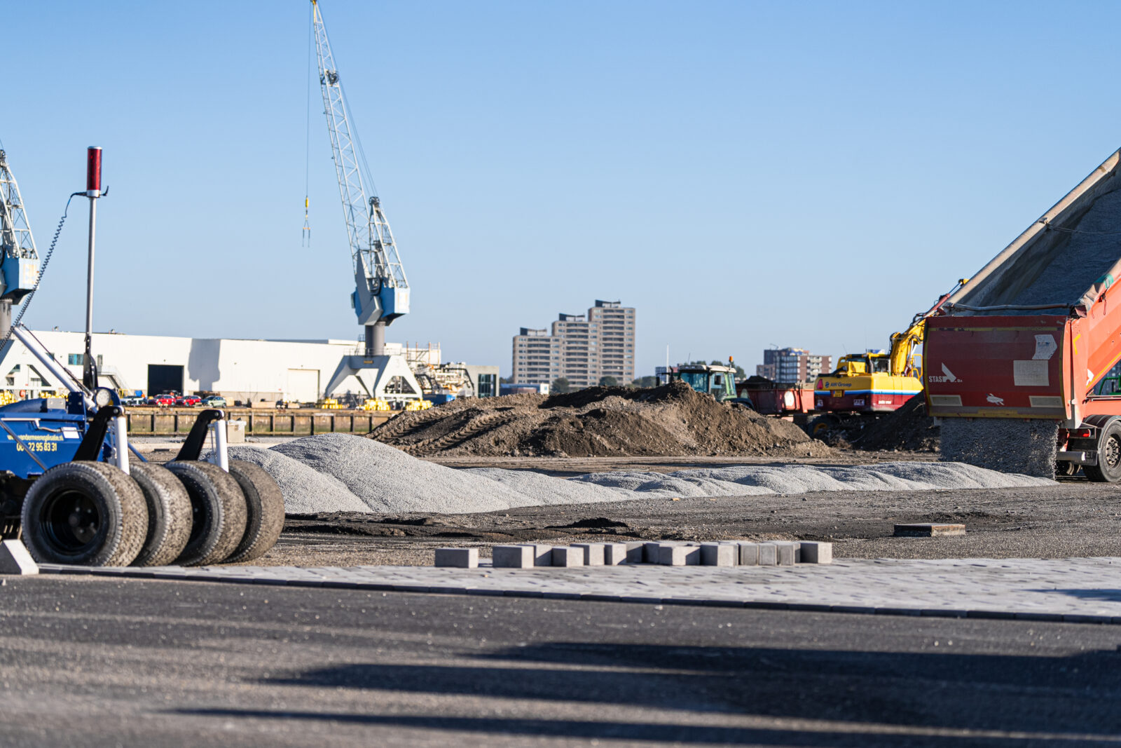 Graafmachine aan het werk op een bouwterrein waar grondwerk wordt uitgevoerd voor een infrastructuurproject.