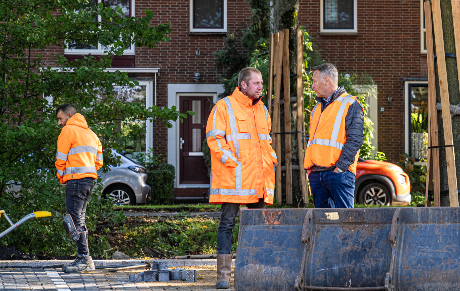 Medewerkers van Ouwejan & F. de Bruijn bespreken de onderhoudswerkzaamheden aan bestrating op locatie.