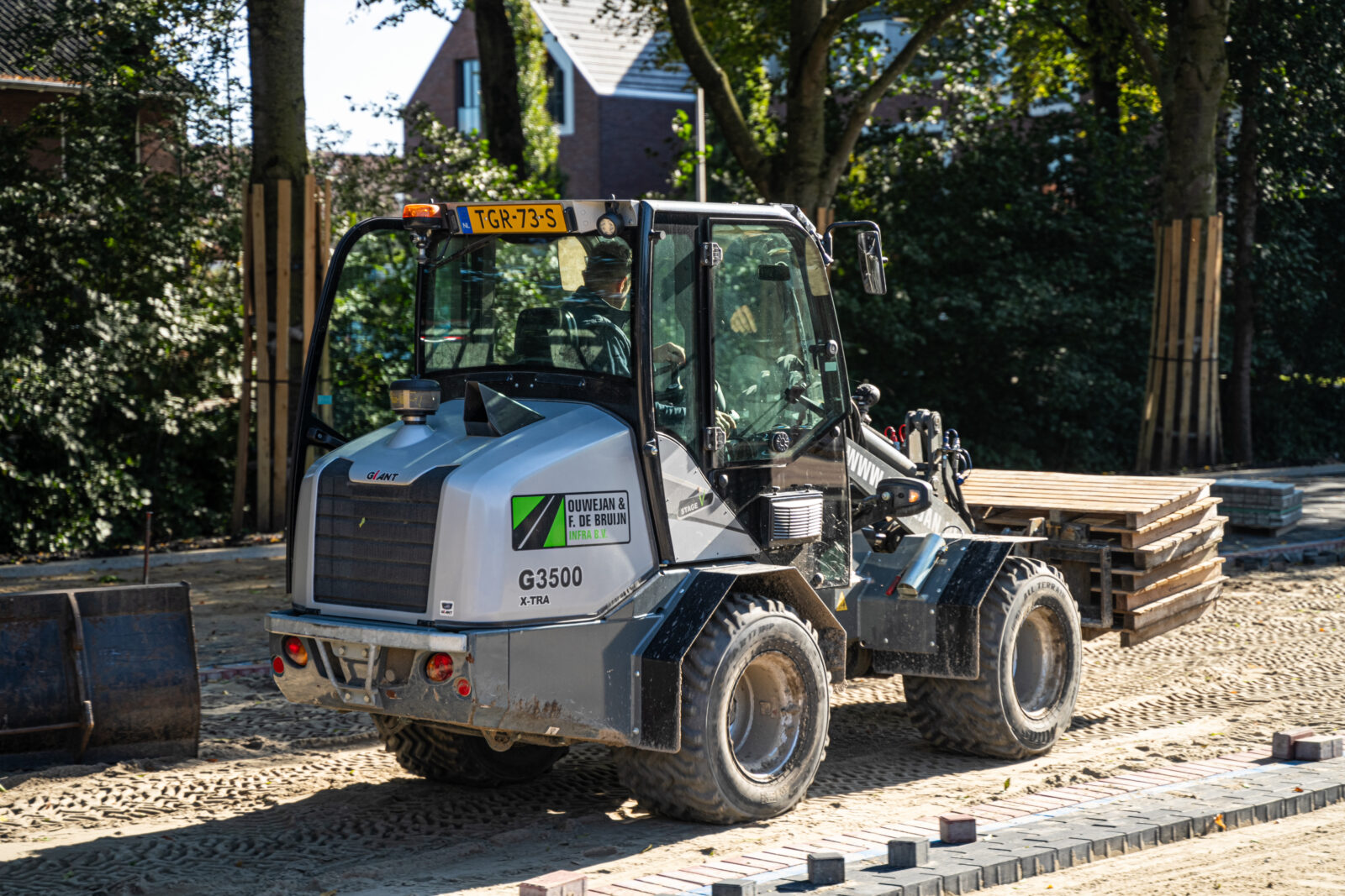 Verplaatsen van bestratingsmateriaal voor de aanleg van een bestratingsproject.